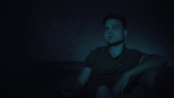 Portrét pohledného mladého muže, citově sledujícího televizi — Stock video