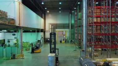 Çalışan insanlarla dolu büyük bir posta deposunun havadan görüntüsü.