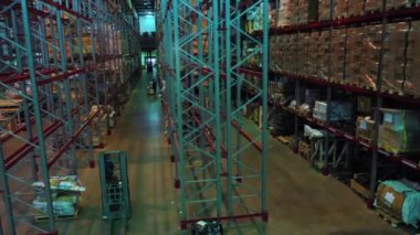 Dev metal raflar arasında çalışan forkliftlerin hava görüntüsü