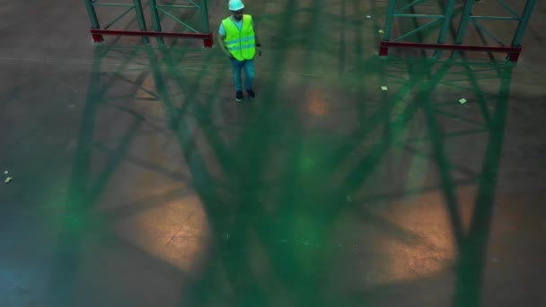 Ingeniero masculino en cascos blancos y un chaleco verde están evaluando el trabajo — Vídeos de Stock