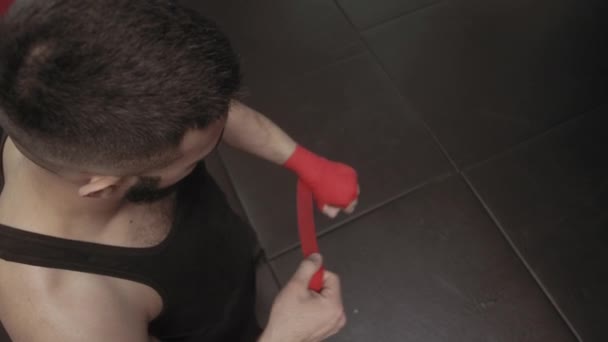 Muscular Fighter kickbox con vendajes rojos contra el fondo de una pared de ladrillo — Vídeos de Stock