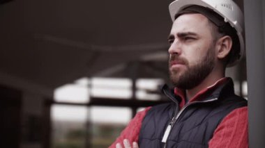 Kasketli ve çelik yelekli bir karavan sürücüsü. İşçi portresini kapat.