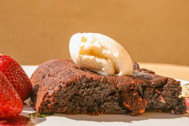 Vanilyalı dondurma ve kırmızı çilekli Brownie. Brownie fındık da dahil