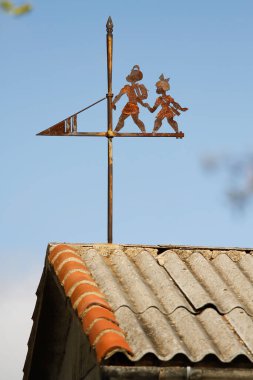 Çatıda rüzgar gülü ve mavi gökyüzü arkaplanı.