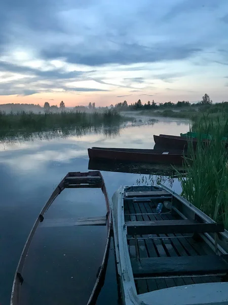 Gün batımında sisli tekneler nehirde