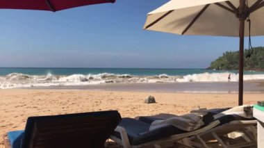 Hint Okyanusu sahilinde tatil. Güneş yatakları, şemsiye, dalgalar, güneş ve güzel manzara.