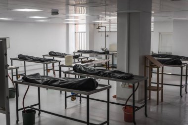 Morgda, morgda, otopsi, defin ya da yakılma için bekleyen insan cesetleri. Ermenistan, Kolombiya 'da çekilmiş. Cesetler büyük, yalnız bir odadalar; siyah kefenlerle kaplılar; salgının kurbanları olabilirler..