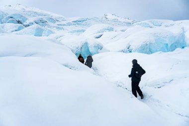 Matanuska Buzulu, Alaska 'da kar üzerinde yürüyüş yapan üç kişilik bir grup. Buz mağaralarına giden yolu takip ediyorlar. Kış tatillerinde aşırı macera. Dağlarda eğleniyoruz.. 