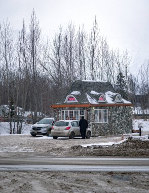 Palmer, Alaska 'da küçük bir lokanta. Dışarıda iki araba ve bir kişi var; müşteriler satın almaya hazır. Kışın bir araba gezisinde çekilmiş. Soğuk, kasvetli bir yer. Gri, bulutlu.