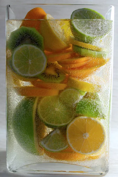 Experiments with water. Lime, oranges. Fruit in water. Spray. Drop of water. Water flow.