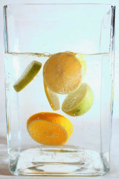 Experiments with water. Lime, oranges. Fruit in water. Spray. Drop of water. Water flow.