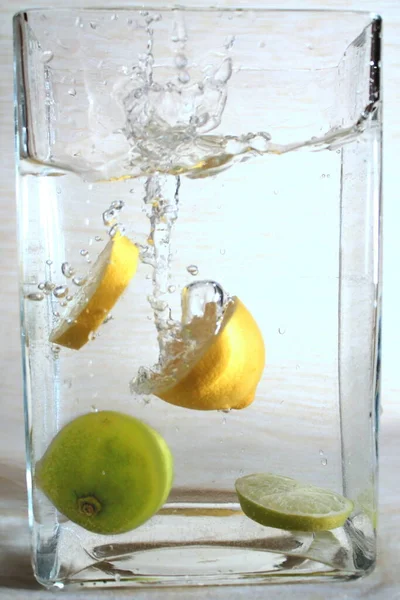 Experiments with water. Lime, oranges. Fruit in water. Spray. Drop of water. Water flow.