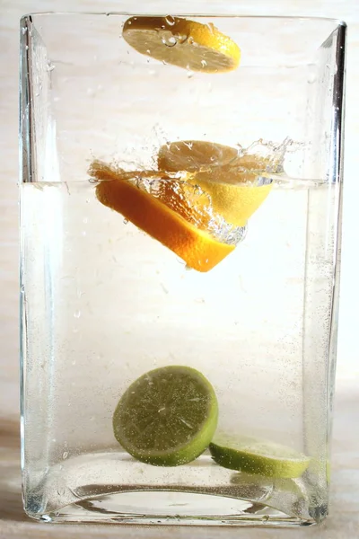 Experiments with water. Lime, oranges. Fruit in water. Spray. Drop of water. Water flow.