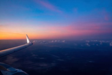 Güneş doğmadan önce renkli gökyüzünde uçaktan hava görüntüsü. Kanat uçağı ve türbinin bir parçası. Yumuşak seçici odak