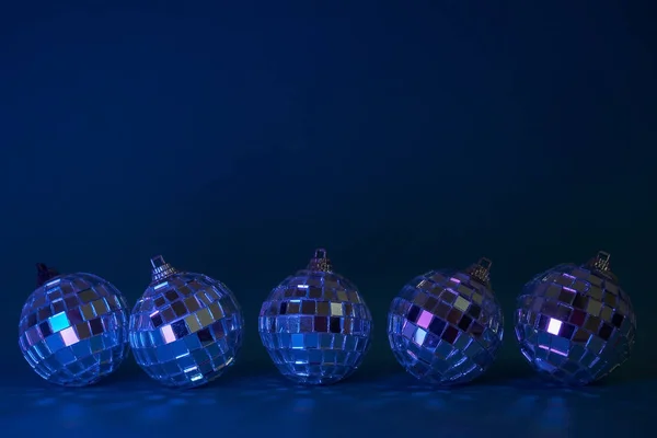 Cinco bolas de Natal disco no fundo azul escuro. Conceito para o Natal, festa e cartão de ano novo. Espaço de cópia — Fotografia de Stock