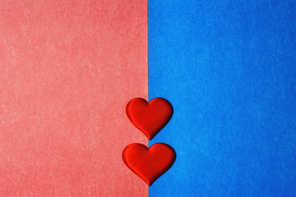 蓝色和粉色纸板背景中间的两个红心的顶部视图。 文本的复制空间，情人节的概念. — 图库照片