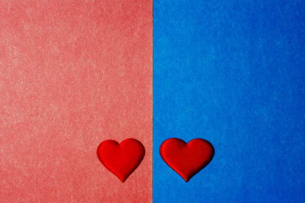 Вид сверху на два красных сердца на голубом и розовом картонном фоне. Копирование текста, концепция Дня Святого Валентина . — стоковое фото