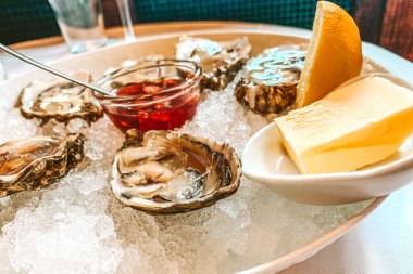 Lezzetli bir tabağın üzerindeki istiridyeler içinde buz ve limon olan sulu bir üründür çünkü sağlıklı bir proteindir ve bu portakala iyi gelir. Deniz ürünleri canlı vitaminler, lezzetli yiyecekler.