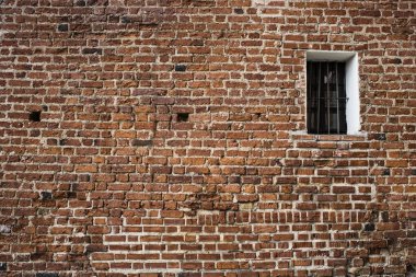 Tuğla kaplı pencereli eski tuğla duvar.