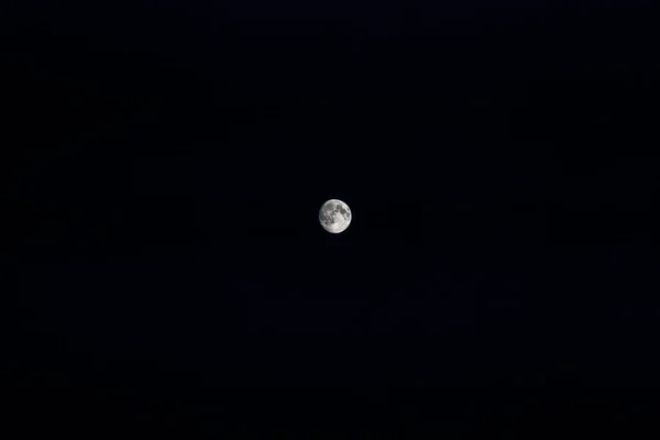 几乎是满月在漆黑的夜空中 从地球上看 — 图库照片
