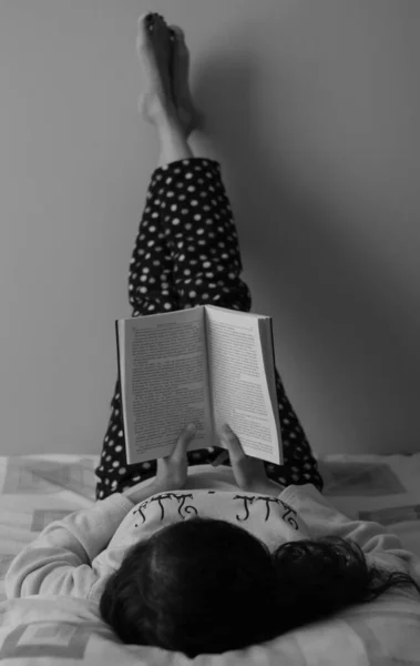 Жінка Лежить Ногами Лежить Стіні Читаючи Книгу — стокове фото