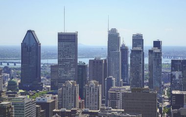 Yaz günü Mount Royal 'dan Montreal manzarası. Tüm ana gökdelenlerin arkasında bir nehir var.