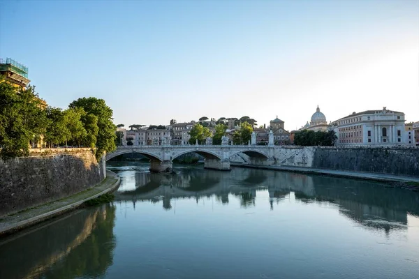Roma 'da Tiber nehri üzerinde sakin bir akşam manzarası ve gün batımının gölgesinde köprüler.