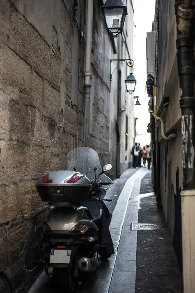 Paris / Fransa - 12 Haziran 2013: Ön planda scooter ile Paris 'in en dar caddesi. Lambalı karanlık dar bir sokak.