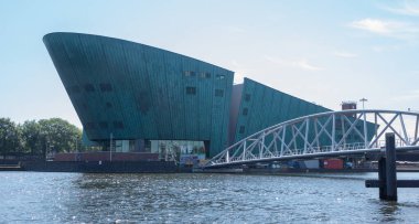 Amsterdam / Hollanda - 1 Temmuz 2015: NEMO Bilim Müzesi ve bir köprü. Yaz güneşli bir gün