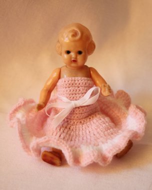 Pembe elbiseli çok eski bir oyuncak bebek..