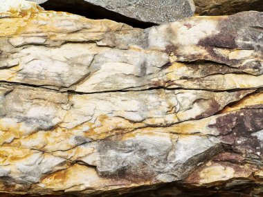 Ormanda ve yürüyüş yollarında bulunan elementlerle yıpranmış engebeli kaya yüzeyi. 