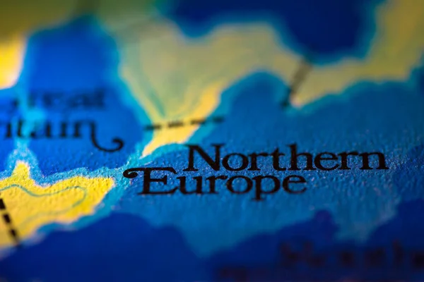 Shallow depth of field focus on geographical map location of Northern Europe region in European continent on atlas
