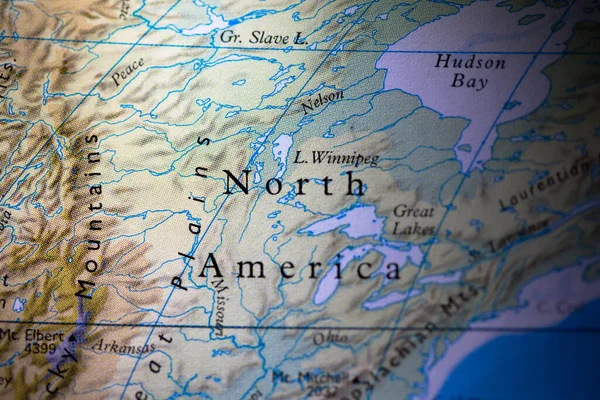 Shallow depth of field focus on geographical map location of country Canada in North America continent on atlas