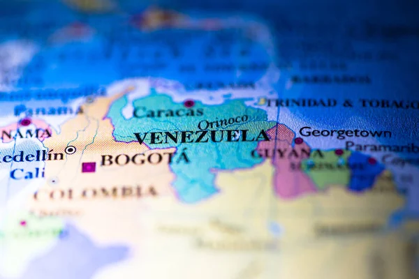 Shallow depth of field focus on geographical map location of country Venezuela in South American continent on atlas