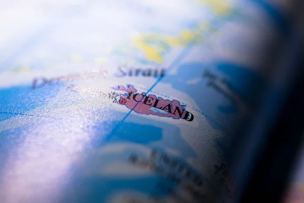 Shallow depth of field focus on geographical map location of country Iceland in Europe continent on atlas