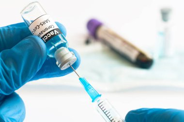 Coronavirus COVID-19 aşı şişesi ve şırınga tıbbi eller konseptine