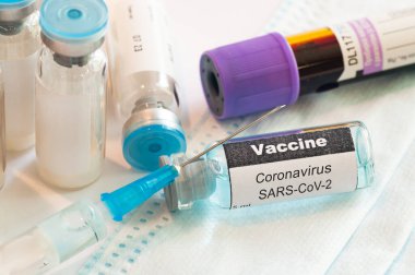 Coronavirus COVID-19 aşısıyla cam ampul şişeli tıbbi şırınga..