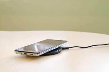 Akıllı telefon şarj cihazına kablosuz şarj. Kablosuz şarj aleti. Boşluğu kopyala.