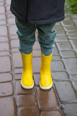 Sarı çizmeli çocuk yağmurda