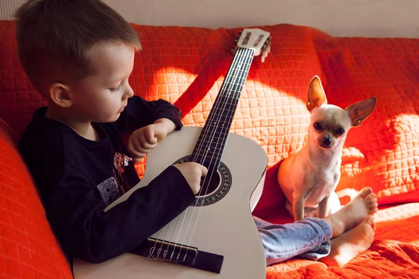 Çocuk akustik gitar çalmayı öğrendi..