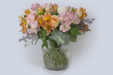 Beyaz arka planda bir vazoda yaz çiçekleri.