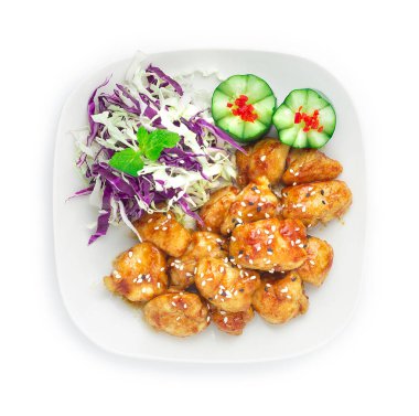 Teriyaki usulü tavuk, Soya Sosu ve Teriyaki Sosu ile pişirilmiş, susam ezmesi Japon yemeği, oyulmuş salatalık ve dilimlenmiş lahana ile süslenmiş.