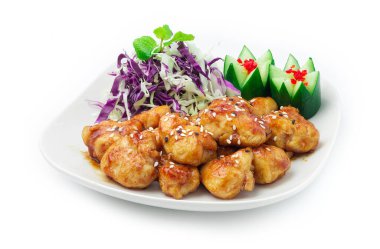 Teriyaki usulü tavuk, Soya sosu ve Teriyaki sosuyla pişirilmiş, susam ezmesi Japon yemeği, oyulmuş salatalık ve dilimlenmiş lahana ile süslenmiş.