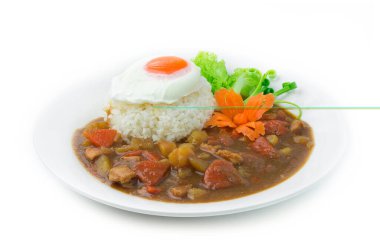 Tavuk körili Japon yemeği pilavı kızarmış yumurta sebzeleri ve oyulmuş havuç şeklindeki güzel yan görünümü süslüyor.