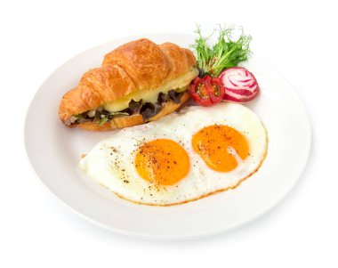 Mozzarella peynirinin içinde kruvasan sandviçi ve kızarmış yumurta ile kırmızı meşe salatası tabağı, karabiber serpiştirmek ve tüm lezzetli süslemeler için tuzlu yemek.