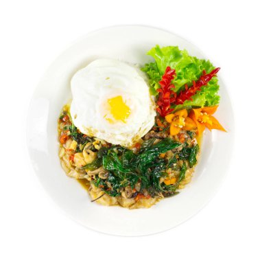 Mürekkep balığı dokunaçları Baharatlı Tayland Fesleğeni acı sosu, pirinçli fesleğenli ve kızarmış yumurta süslemeli baharatlı Tayland yemeği üst görünümü.