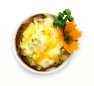 Mozzarella peynirinin üzerine sos soslu patates kreması. Klasik tatil geleneklerini kaplıyor. Yemek, oyulmuş havuç ve beyaz arka planda izole edilmiş taze soğan.