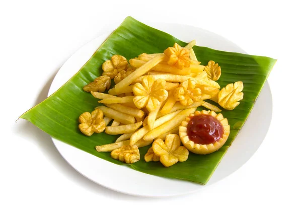 Frenchfries potato chip carved flower and leaf shape out on banana leaf the simply fried of American English style the best snack of the world serving for break time party watching movie with tomato sauce in carved potato dipping bowl