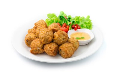 Kızarmış tavuk köftesi Asya yemeği Tayland usulü erik tatlı biber sosu oyulmuş sebzeler ve biber oyulmuş yan görüş.