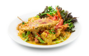 Kızarmış Mavi Yengeç ile karıştırılmış yumurta sarısı Tayland yemeği karışımı oyulmuş kırmızı biber, taze soğan ve yeşil meşe salatası yan görünümü.